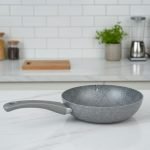 O.M.S. brown granite non-stick wok pan made in Turkey, displaying stir-fry cooking with 90% less oil and fresh ingredients on a kitchen counter.