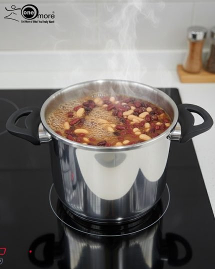 Falez 7-liter stainless steel pressure cooker made in Turkey sitting on a black stovetop, showing steam venting and food cooking inside, available at ONEMORE.