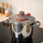 Falez 9-liter stainless steel pressure cooker with grey and red safety lid, sitting on a stovetop, featuring Turkish manufacturing quality – available at ONEMORE.