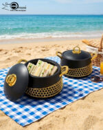 A luxury set of three insulated hotpot food warmers in matte black and white finishes featuring decorative gold hexagonal trim and polished gold handles, displayed in kitchen, dining, and outdoor settings.