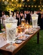 Elegant One More 4.5 liter diamond-cut glass beverage dispenser with a silver spigot and decorative lid, filled with lemon-infused water on a table setting.