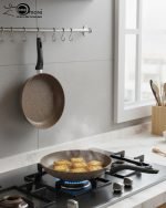 Falez 9-piece brown speckled granite non-stick cookware set displayed on a kitchen counter, featuring a fry pan, shallow casserole, and three deep pots with glass lids - Made in Turkey.