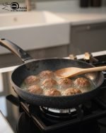 Falez 9-piece black granite non-stick cookware set including deep pots, shallow casserole, and fry pan with glass lids, displayed on a marble kitchen countertop.