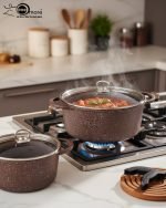 Falez 9-piece brown granite non-stick cookware set including deep pots, shallow casserole, and fry pan with glass lids, Made in Turkey, displayed on a marble kitchen counter.