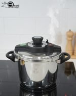 Falez 7-liter stainless steel pressure cooker made in Turkey sitting on a black stovetop, showing steam venting and food cooking inside, available at ONEMORE.
