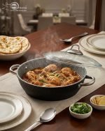 Falez 9-piece black granite non-stick cookware set including fry pan, shallow casserole, and three pots with glass lids and stainless steel handles, arranged on a wooden table.