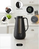 1 Litre vacuum flask thermos jug featuring a textured geometric design and gold accent strip. Shown in Off-White, Grey, and Black colors on a marble kitchen counter with callouts highlighting the glass interior, sleek handle, and air-tight cap.