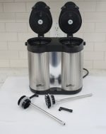 Double compartment stainless steel thermal airpot with 4-liter total capacity (2+2 liters), featuring dual pump dispensers, a carry handle, and a rotating base, shown pouring milk tea into a white cup.