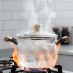 A collection of four transparent borosilicate glass cooking pots in different sizes featuring wooden handles and lids, shown in a modern kitchen setting and serving food on a dining table.