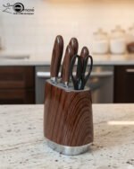 A 6-piece kitchen knife set featuring stainless steel blades with dark wood-grain patterned handles and a matching oval storage block on a granite countertop.