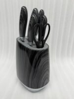 A professional 6-piece kitchen knife set featuring dark grey wood-grain patterned handles and a matching universal storage block, displayed on a white marble countertop with fresh lemons and herbs.