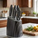 A professional 6-piece kitchen knife set featuring dark grey wood-grain patterned handles and a matching universal storage block, displayed on a white marble countertop with fresh lemons and herbs.