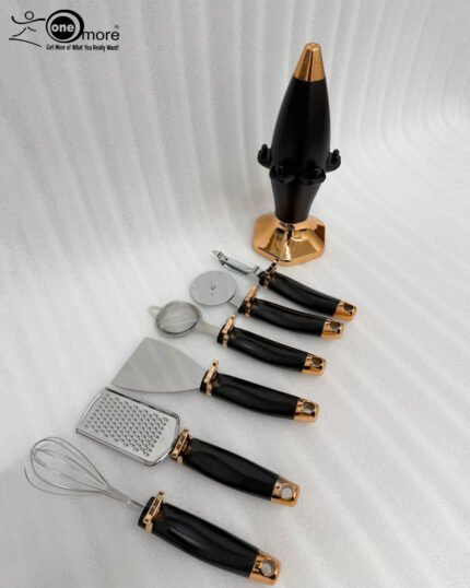 A 7-piece luxury kitchen tool set featuring black and rose gold handles, including a whisk, pizza cutter, and grater, arranged on a matching black and gold rotating stand on a marble countertop.