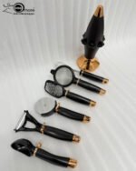 A premium 7-piece kitchen gadget set with rose gold and black handles, featuring a pizza cutter, whisk, and grater, organized on a sleek black rotating stand.