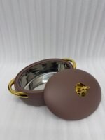 A set of three modern, oval-shaped insulated hotpots with gold handles and knobs, shown in chocolate brown, grey, and white colors on wooden and marble dining surfaces.