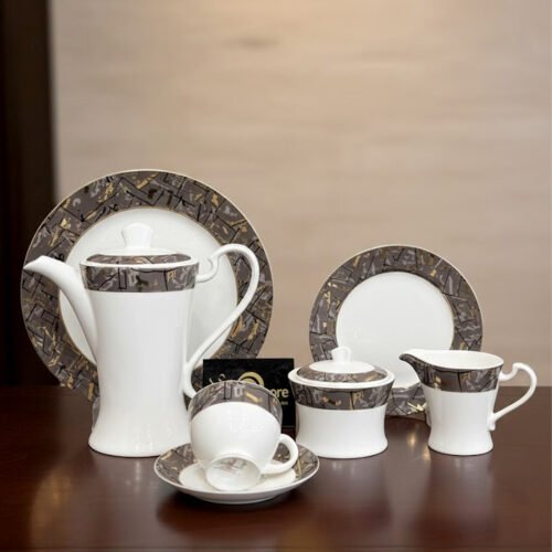 Minimalist 24-piece white porcelain tea set with vertical ribbed texture and a thin black geometric border, displayed in a warm lit room.