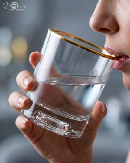Close-up of a person drinking from a luxury RCR-inspired crystal glass with a gold-plated rim and heavy base, showcasing elegant tableware.