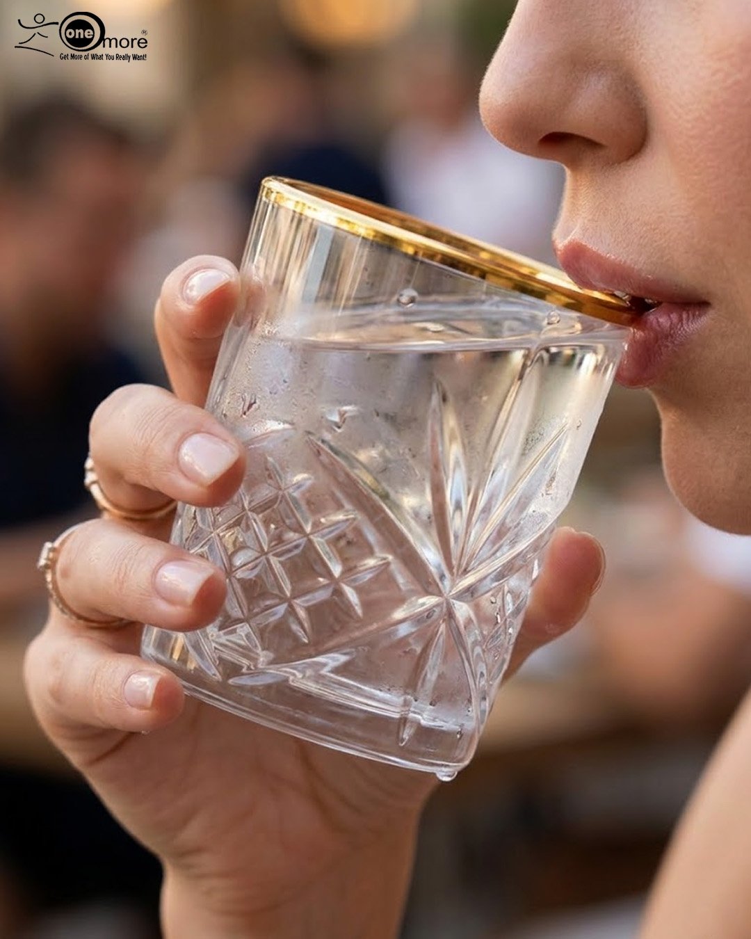 1 Close-up of a person drinking from a luxurious RCR-inspired crystal glass featuring an intricate diamond-cut pattern and a polished golden rim.