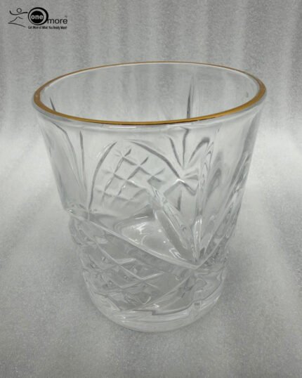 Close-up of a person drinking from a luxurious RCR-inspired crystal glass featuring an intricate diamond-cut pattern and a polished golden rim.