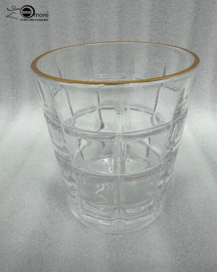 Close-up of a person drinking from a textured RCR-inspired crystal water glass with a luxurious gold rim and geometric square pattern.