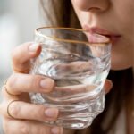 A set of six clear crystal drinking glasses featuring a unique twisted, rippled texture and a thin decorative gold rim on a neutral background.
