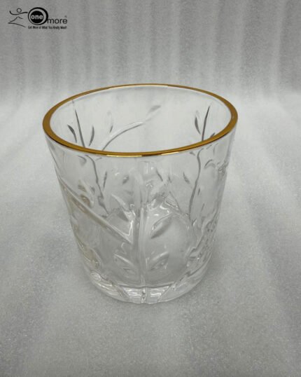 Close-up of a person drinking from an elegant crystal water glass featuring an embossed leaf pattern and a polished gold rim, highlighting the clarity and luxury design.