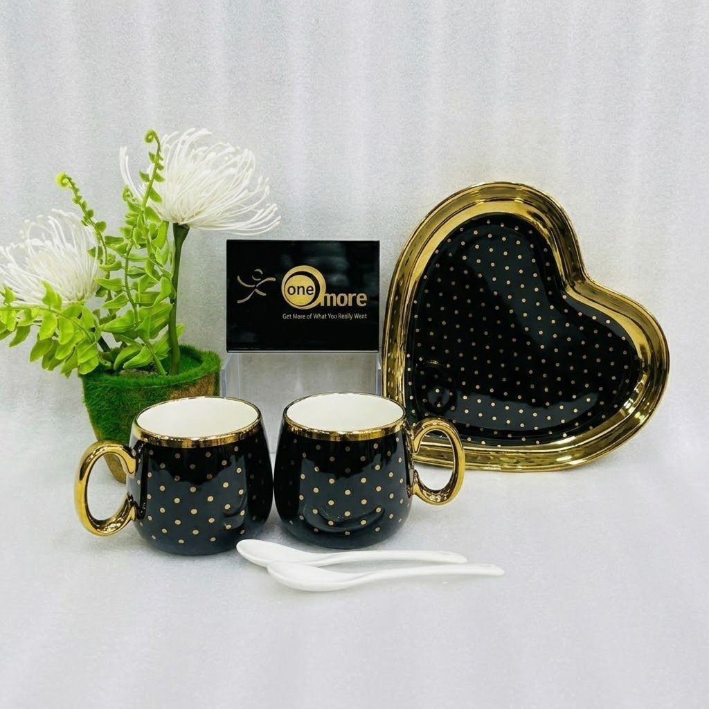 Black Five-piece stoneware couple set featuring two polka-dotted mugs with gold handles, a matching heart-shaped tray, and two white spoons, available in black, navy, sky blue, pink, and white.