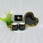 A luxury 5-piece stoneware coffee set for couples featuring two mugs with gold lattice patterns, a matching heart-shaped tray with gold trim, and two white spoons, available in multiple colors including black, green, and pink.