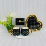 A luxury 5-piece stoneware coffee set for couples featuring two mugs with gold lattice patterns, a matching heart-shaped tray with gold trim, and two white spoons, available in multiple colors including black, green, and pink.