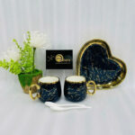 A luxury 5-piece stoneware coffee set for couples featuring two round marble-patterned mugs with gold handles, two white spoons, and a matching heart-shaped gold-rimmed tray, available in black, white, green, blue, and yellow.