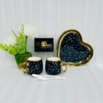 A 5-piece stoneware couple's coffee set featuring two star-patterned mugs with gold handles, two white spoons, and a matching gold-rimmed heart-shaped tray on a clean white background.