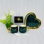 A luxury 5-piece stoneware coffee set for couples featuring two round marble-patterned mugs with gold handles, two white spoons, and a matching heart-shaped gold-rimmed tray, available in black, white, green, blue, and yellow.