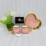 A luxury 5-piece stoneware coffee set for couples featuring two mugs with gold lattice patterns, a matching heart-shaped tray with gold trim, and two white spoons, available in multiple colors including black, green, and pink.