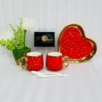 A 5-piece stoneware couple's coffee set featuring two star-patterned mugs with gold handles, two white spoons, and a matching gold-rimmed heart-shaped tray on a clean white background.