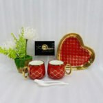 A luxury 5-piece stoneware coffee set for couples featuring two mugs with gold lattice patterns, a matching heart-shaped tray with gold trim, and two white spoons, available in multiple colors including black, green, and pink.