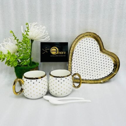 Five-piece stoneware couple set featuring two polka-dotted mugs with gold handles, a matching heart-shaped tray, and two white spoons, available in black, navy, sky blue, pink, and white.