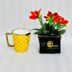 Modern ceramic coffee mug with gold handle and geometric trellis pattern, available in black, green, red, white, and yellow.