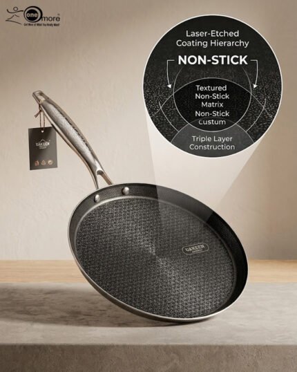 A professional-grade laser-etched non-stick stainless steel crepe pan with a textured honeycomb surface and ergonomic silver handle, shown on a kitchen counter and an induction cooktop.