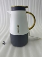 Three elegant 1.5-liter stainless steel thermal flasks in rose gold, slate grey, and charcoal blue bases with white bodies and gold-plated handles, displayed on a marble kitchen countertop.