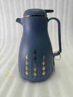 Two elegant 1-liter thermal carafes in matte black and slate blue with gold decorative patterns, displayed on a kitchen counter next to a coffee machine.