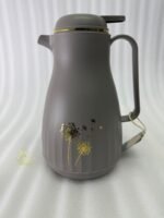 Two 1-liter insulated thermal flasks in Earth Grey and Creamy Beige, featuring golden dandelion designs and ergonomic handles, displayed on a kitchen countertop.