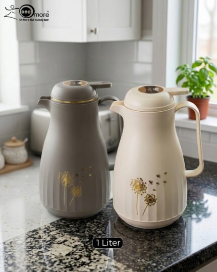 Two 1-liter insulated thermal flasks in Earth Grey and Creamy Beige, featuring golden dandelion designs and ergonomic handles, displayed on a kitchen countertop.