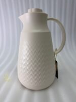 A 1-liter insulated thermal flask with a 3D diamond-patterned matte body, featuring a curved handle and a spout, shown in black and beige color options on a kitchen countertop.