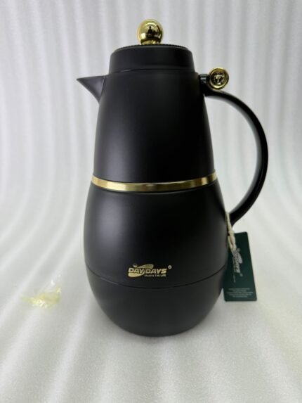 Three DayDays 1-liter luxury thermal flasks in white, black, and purple with gold accents displayed on a granite kitchen countertop.