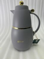 Three DayDays 1-liter luxury thermal flasks in white, black, and purple with gold accents displayed on a granite kitchen countertop.