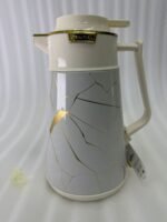 Three elegant 1-liter vacuum flasks in black, grey, and cream colors, featuring a golden Kintsugi-inspired marble pattern on a kitchen countertop.