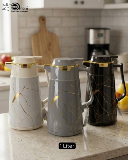 Three elegant 1-liter vacuum flasks in black, grey, and cream colors, featuring a golden Kintsugi-inspired marble pattern on a kitchen countertop.