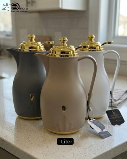 Three 1-liter thermal flasks in grey, beige, and white featuring matte finishes, elegant gold lids, and ergonomic handles on a marble countertop.