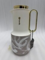 A trio of Feenik 1-liter luxury thermal flasks in cream with gold handles and lids, featuring three different artistic patterns on the base, displayed on a white marble kitchen counter.