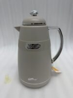 Three 1-liter DayDays thermal flasks in Dusty Rose, Warm Sand, and Stone Grey arranged on a granite kitchen countertop.